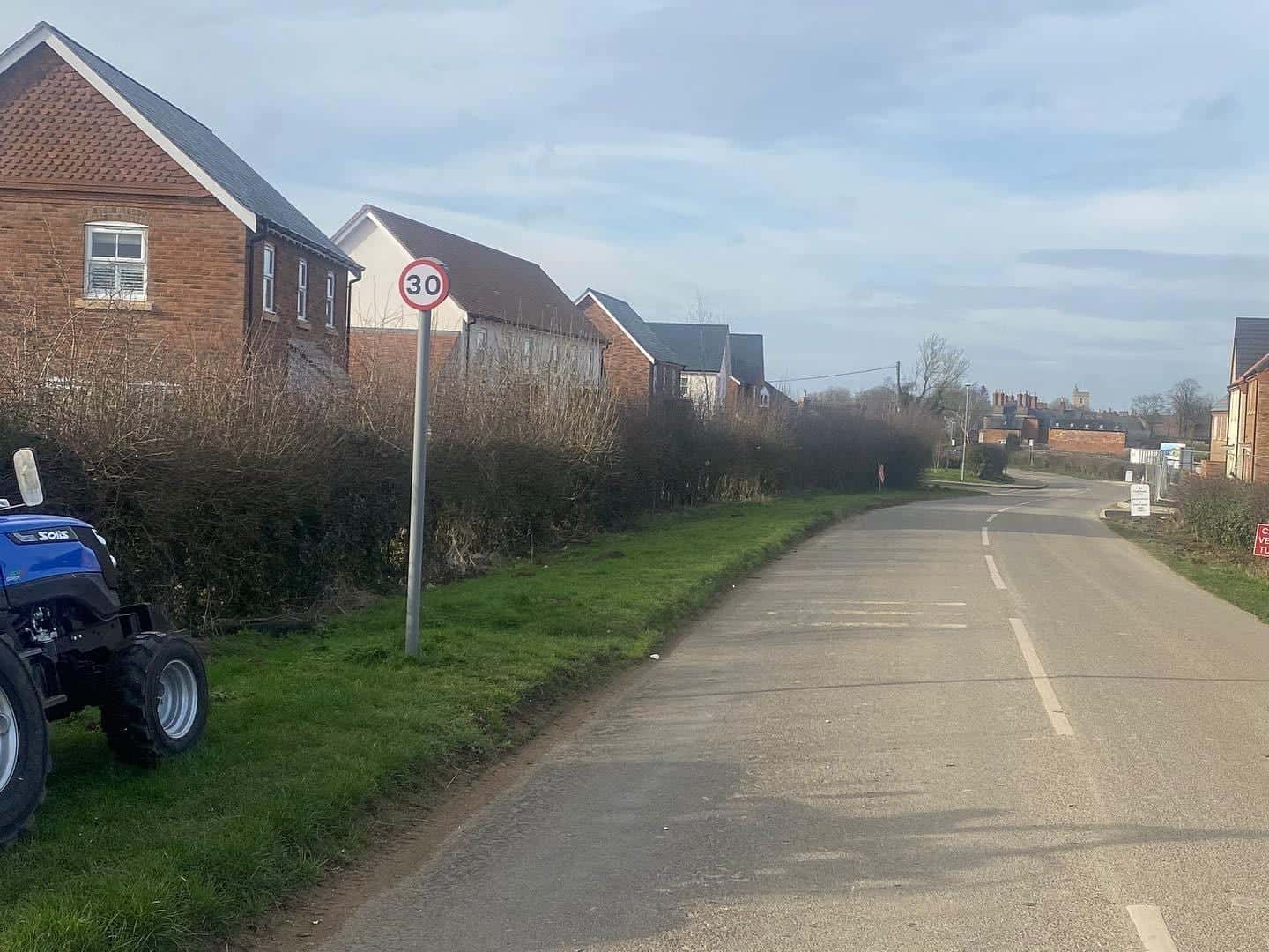 Compact tractor cutting an estate verge