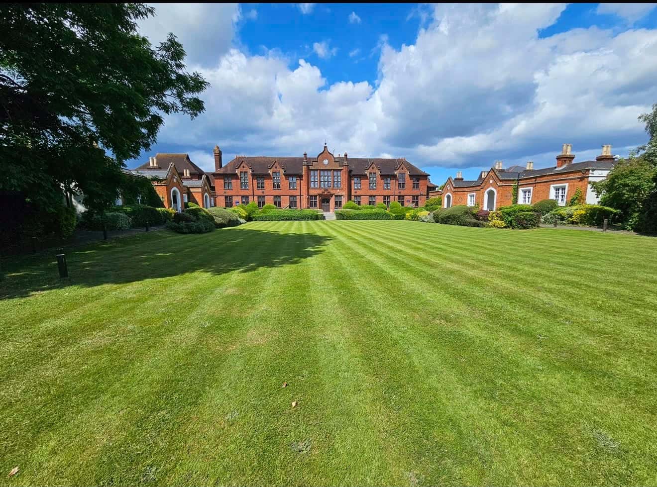 Striped lawn in front of a red-brick school